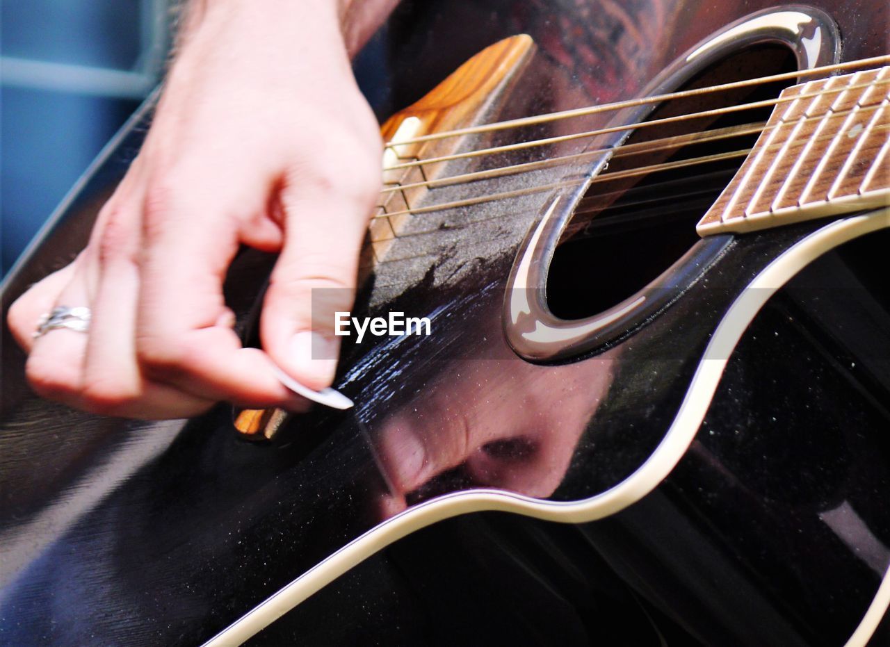 Cropped hand of man playing guitar