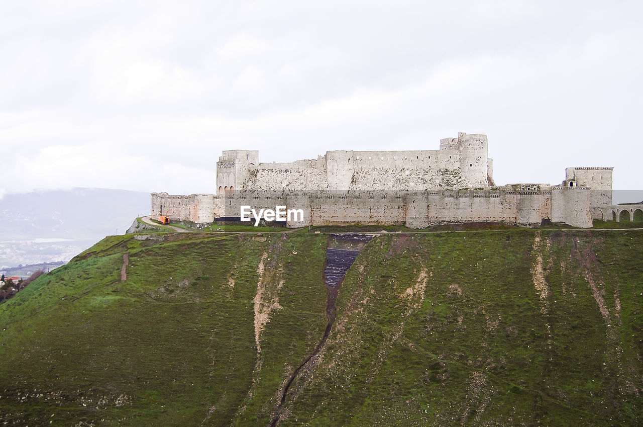 LOW ANGLE VIEW OF FORT AGAINST MOUNTAIN