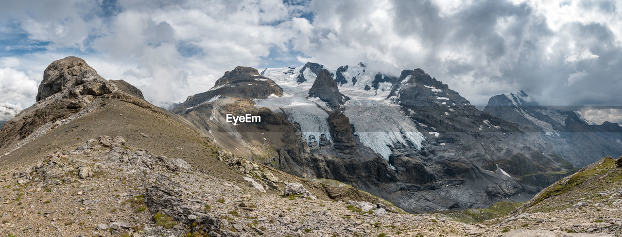 Scenic view of mountains against cloudy sky