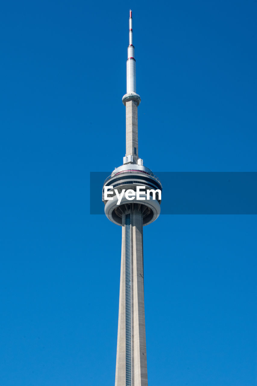 Low angle view of communications tower against blue sky