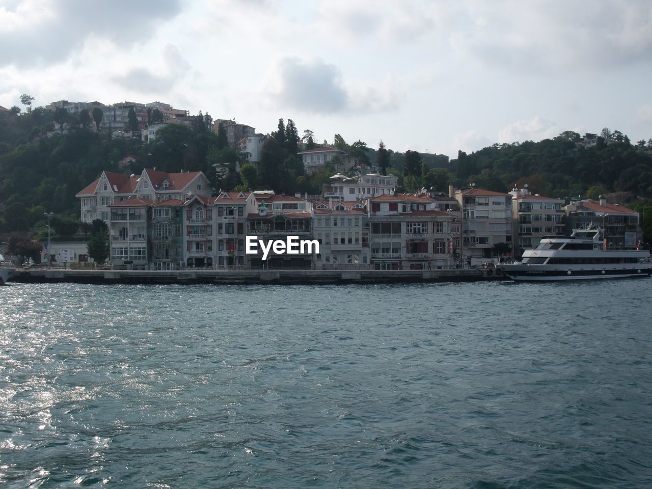 BUILDINGS BY RIVER AGAINST SKY IN CITY