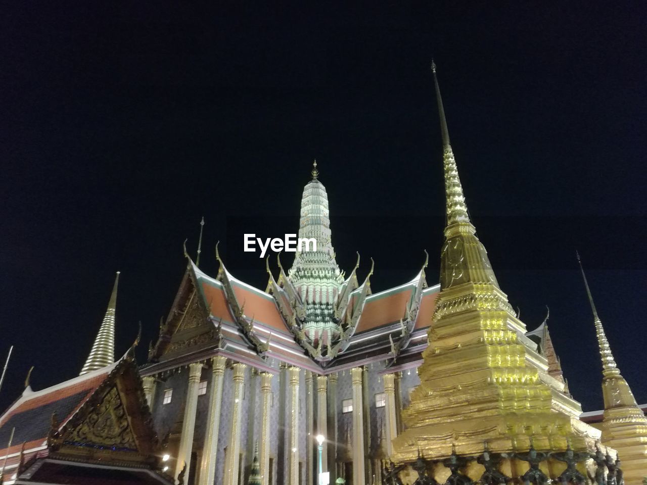 LOW ANGLE VIEW OF ILLUMINATED BUILDINGS AGAINST SKY AT NIGHT