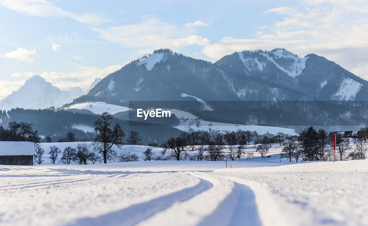 SNOW COVERED MOUNTAINS AGAINST SKY