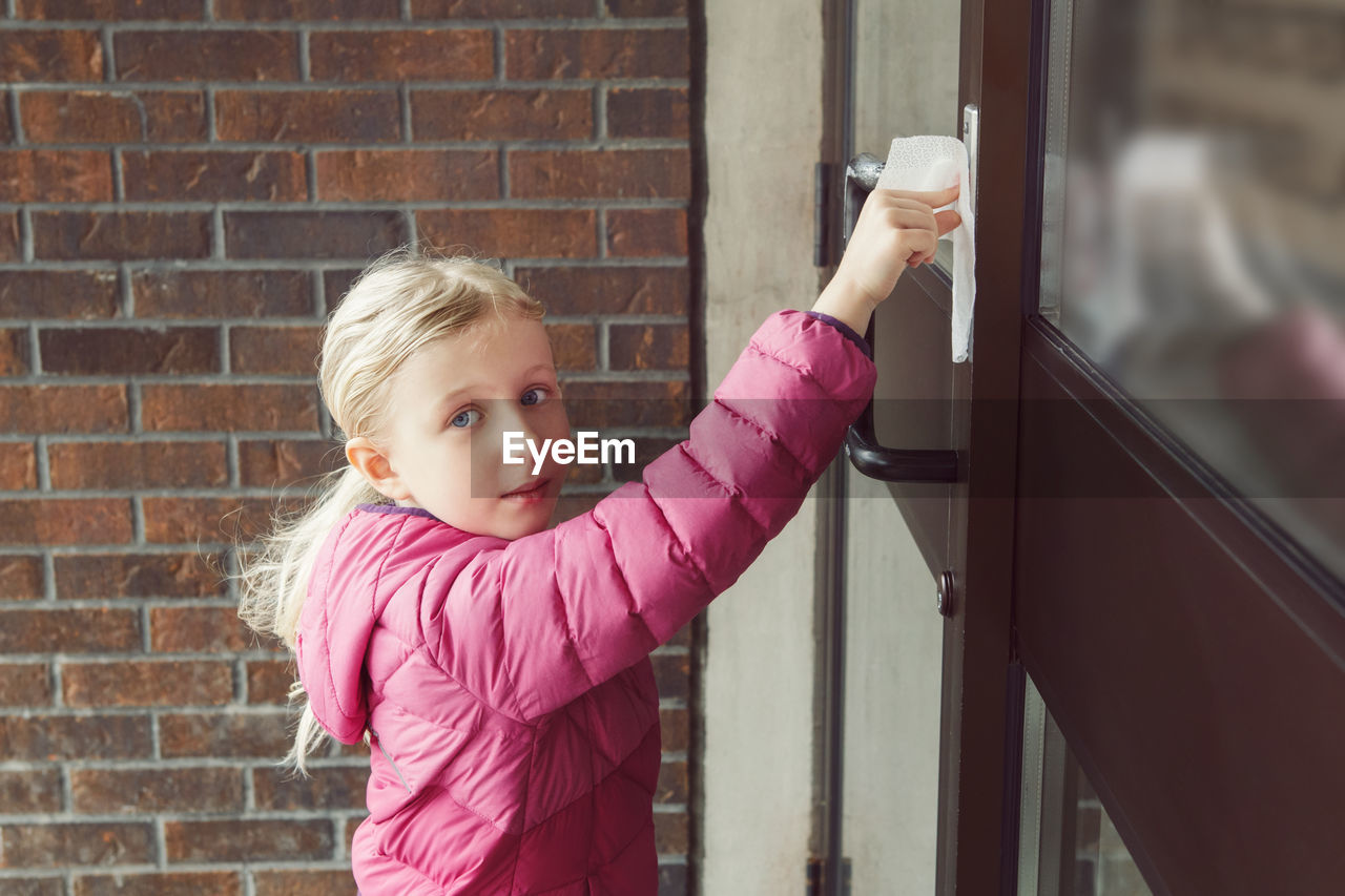 Girl with napkin pressing doorbell