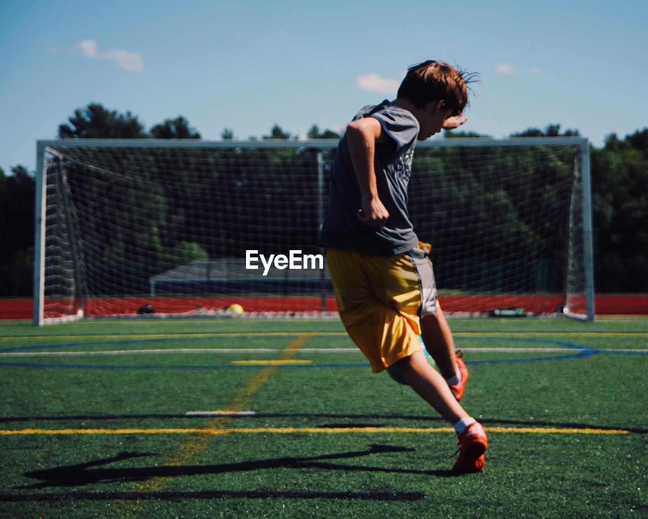 Rear view of boy playing on soccer field