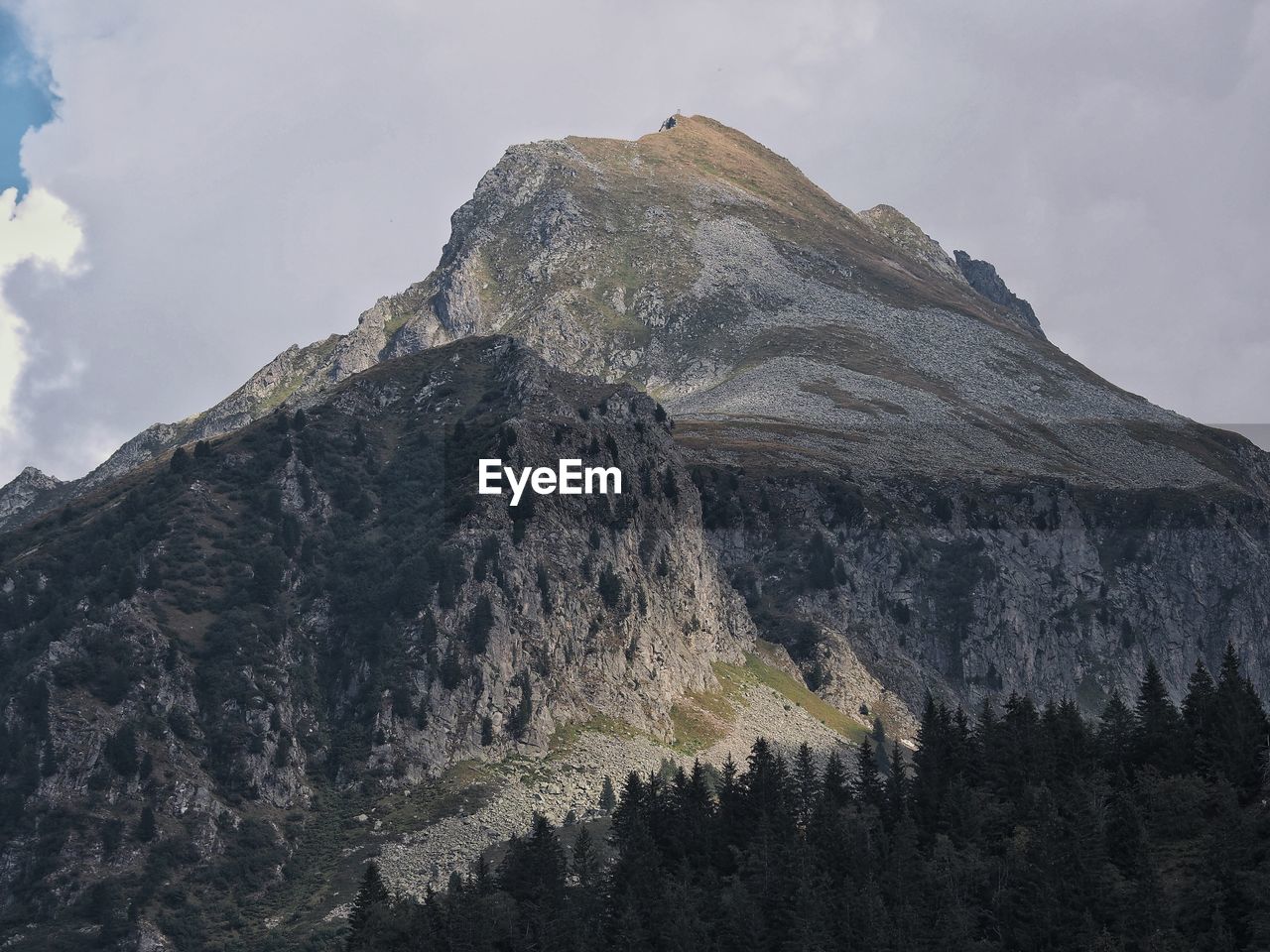 Low angle view of mountain range against cloudy sky