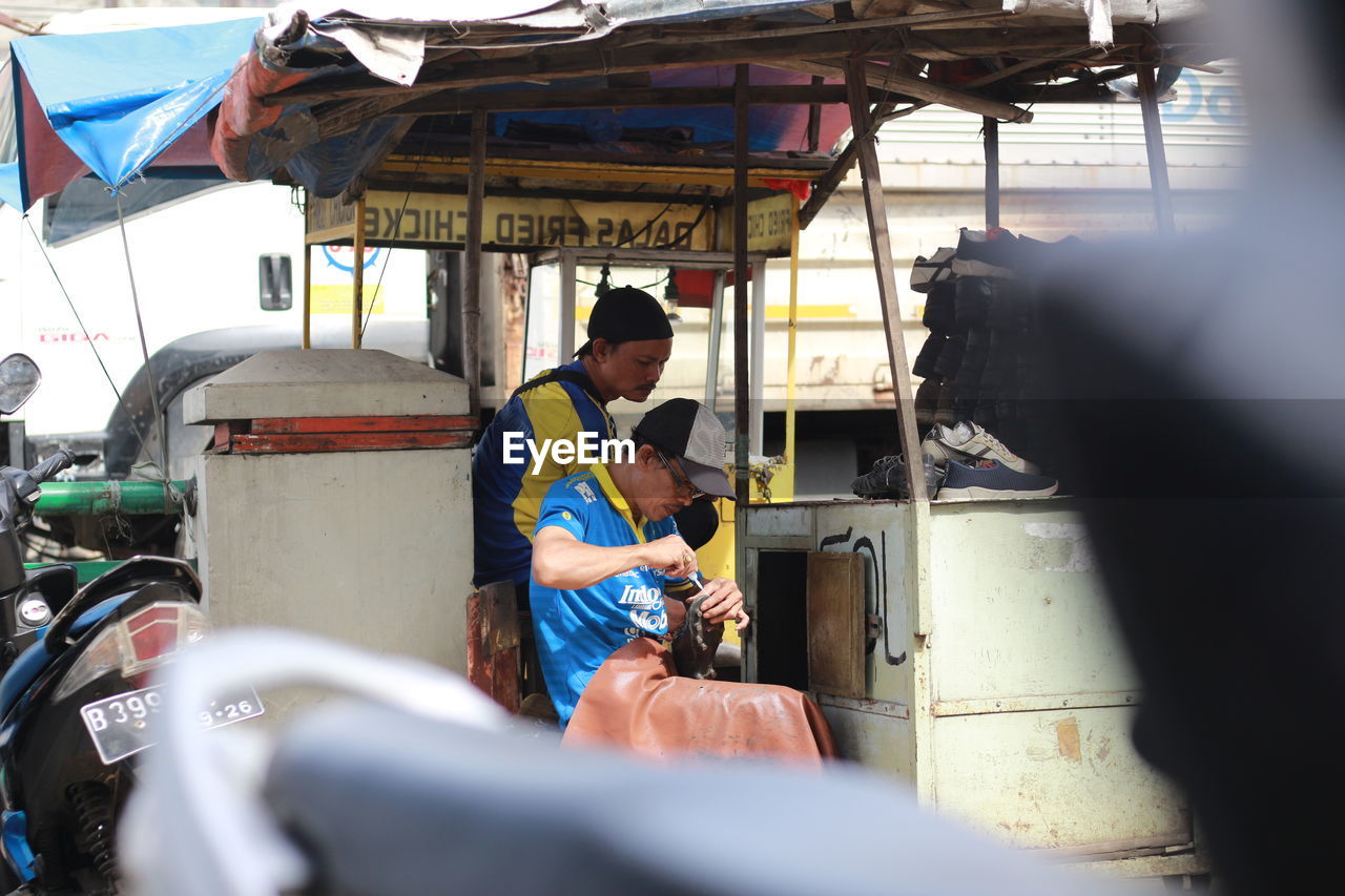 adult, men, focus on background, occupation, transportation, two people, day, working, selective focus, mode of transportation, vehicle, mature adult, business, clothing, candid, outdoors, skill, protection, business finance and industry, sitting, person, women, togetherness