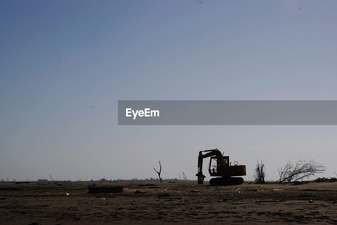 horizon, natural environment, sky, sea, sand, nature, coast, land, environment, vehicle, copy space, land vehicle, shore, machinery, industry, transportation, landscape, clear sky, no people, mode of transportation, construction machinery, field, construction industry, beach, outdoors, day, morning