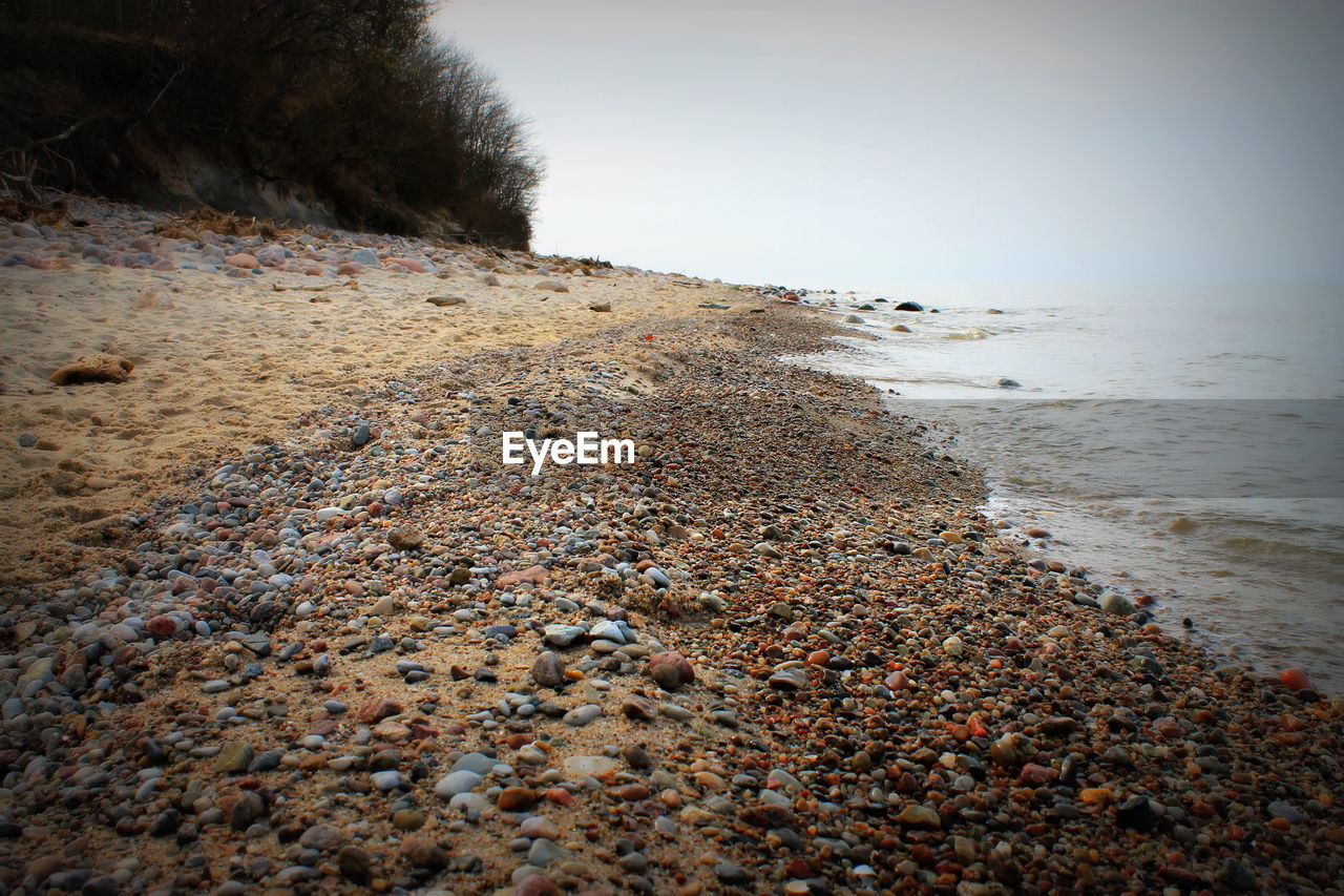 Pebbles on beach against sky