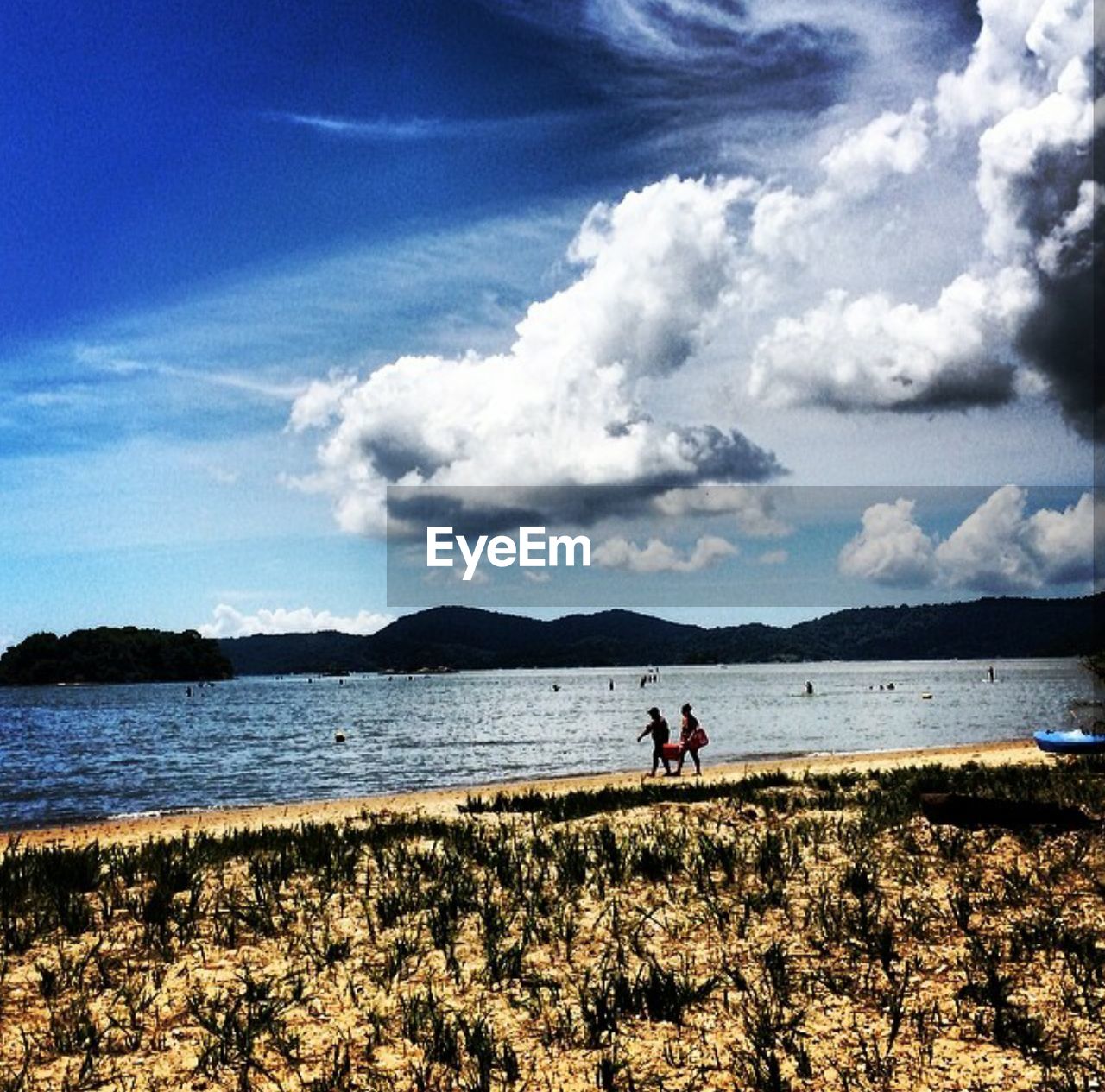 WOMAN ON BEACH AGAINST SKY