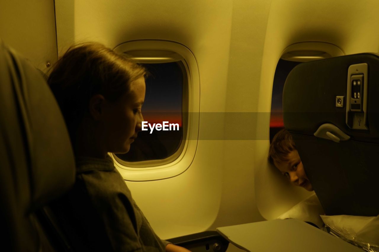 Side view of woman sitting in airplane