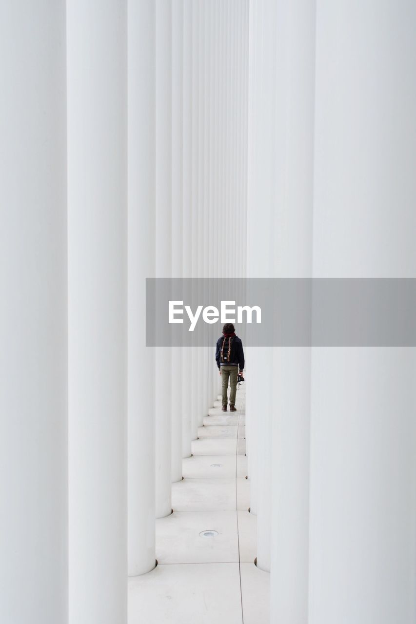 Rear view of man walking in corridor