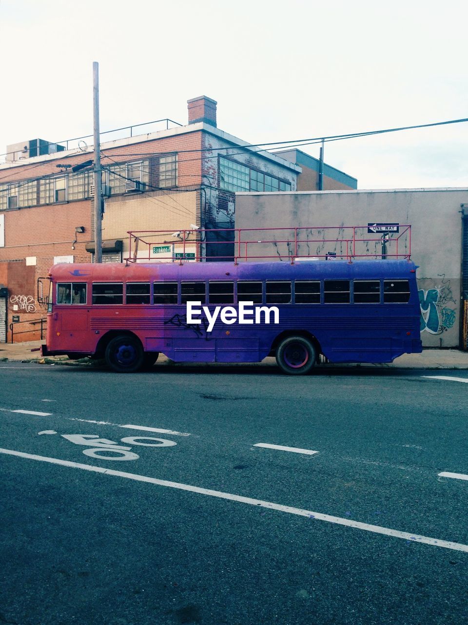 Bus on street by building against clear sky