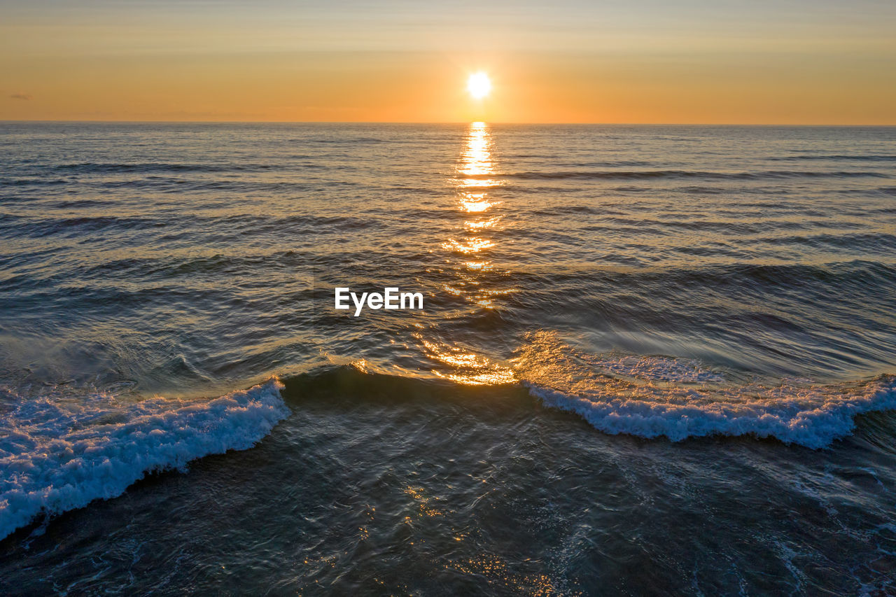 SCENIC VIEW OF BEACH AGAINST SKY DURING SUNSET