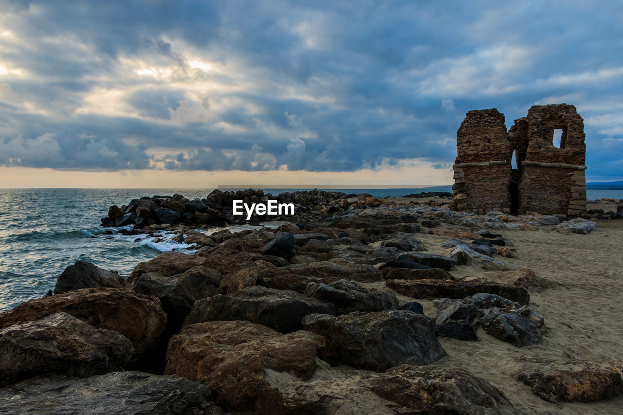 Rocks on beach against sky
