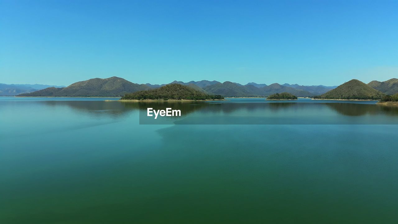Scenic view of lake against clear blue sky