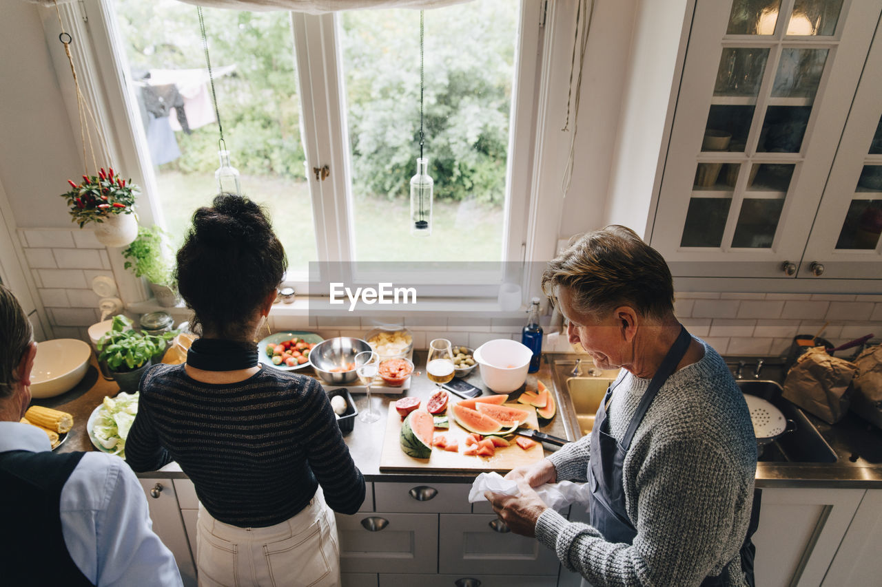 High angle view of senior man and woman preparing dinner at kitchen counter