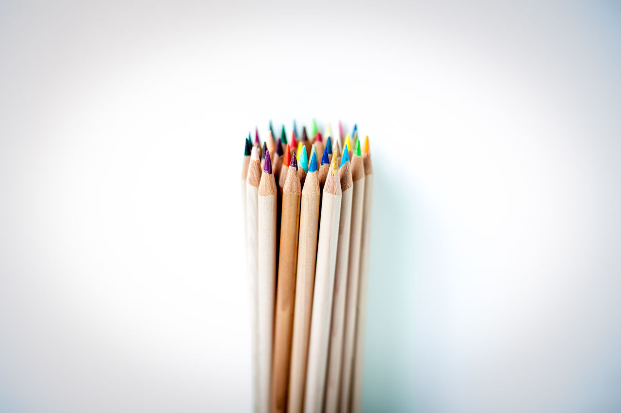 Close-up of colored pencils over white background