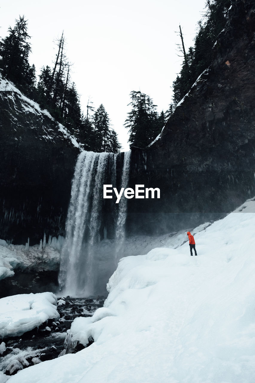 Waterfall along snow covered landscape