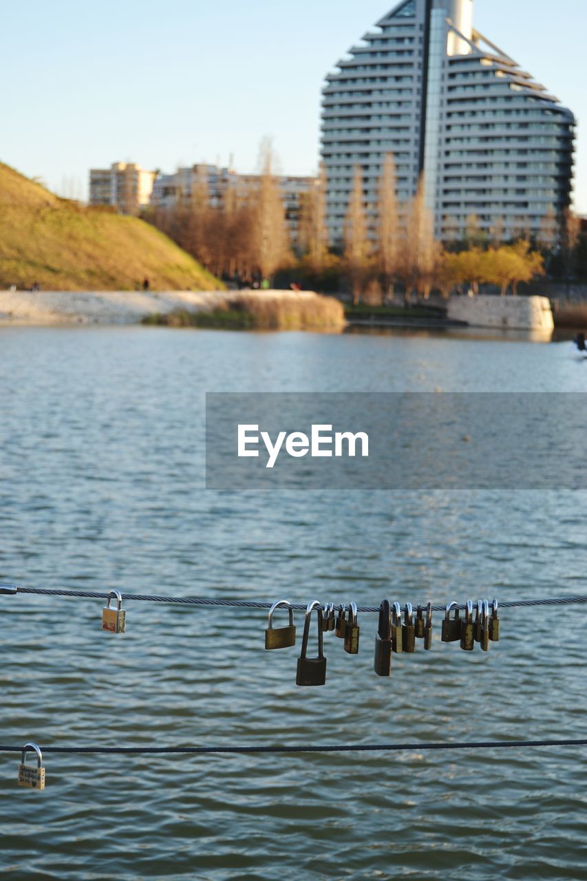 Padlocks attached on cables over lake