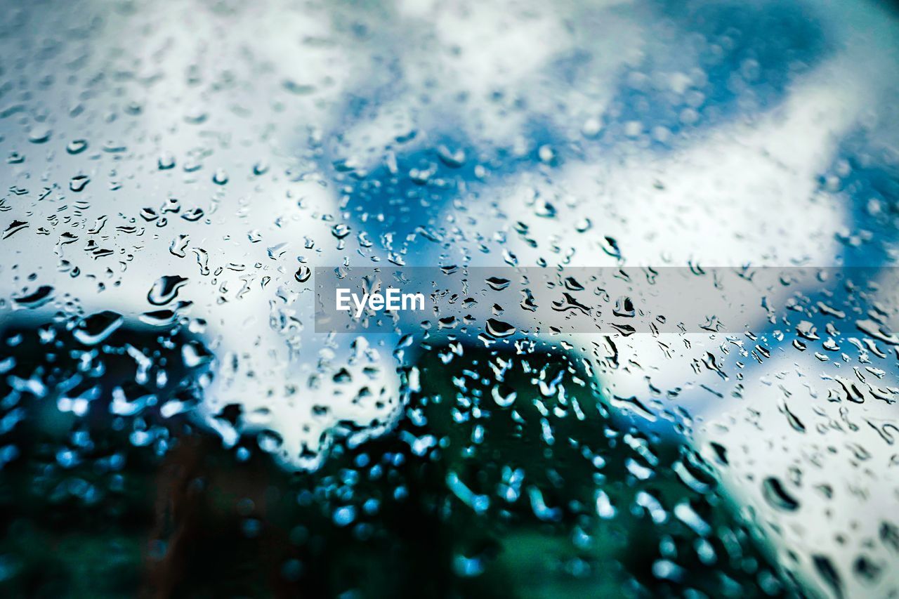CLOSE-UP OF RAINDROPS ON GLASS WINDOW