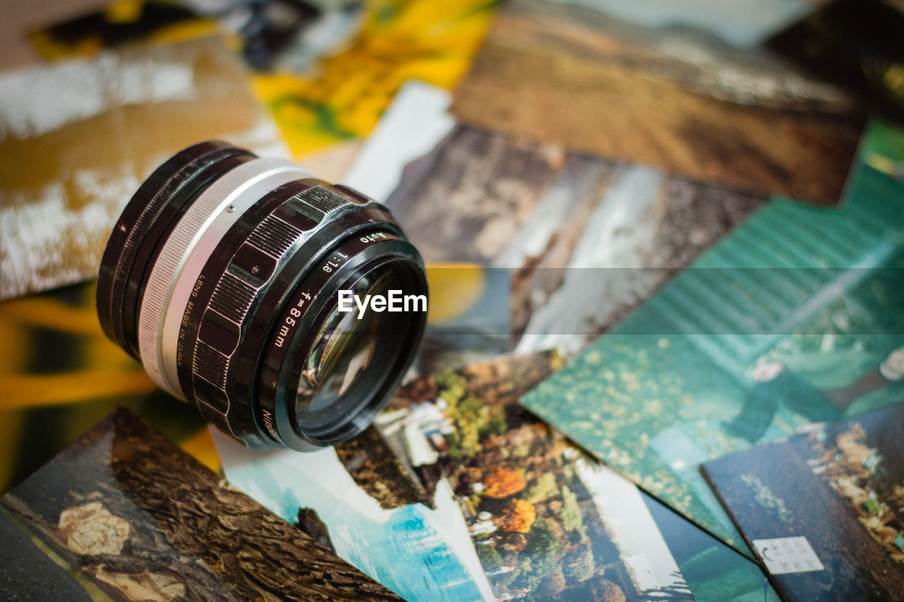 Close-up of lens over photographs
