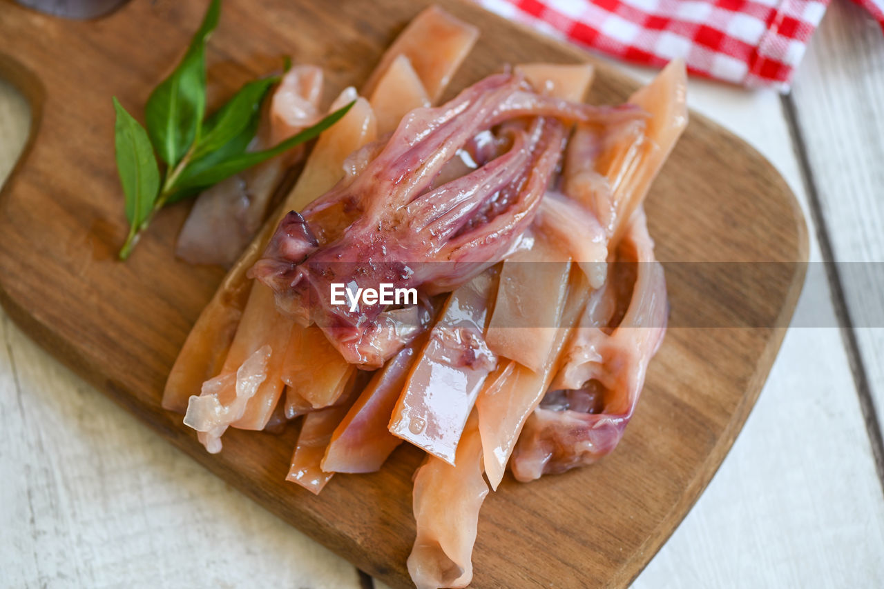 food and drink, food, freshness, cutting board, dish, meat, wood, indoors, prosciutto, no people, produce, table, fast food, high angle view, pork, healthy eating, processed meat, cuisine, vegetable, close-up, still life, wellbeing, herb, slice, ham, meal, italian food