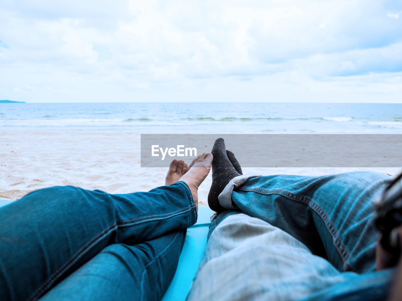 LOW SECTION OF PERSON RELAXING ON BEACH