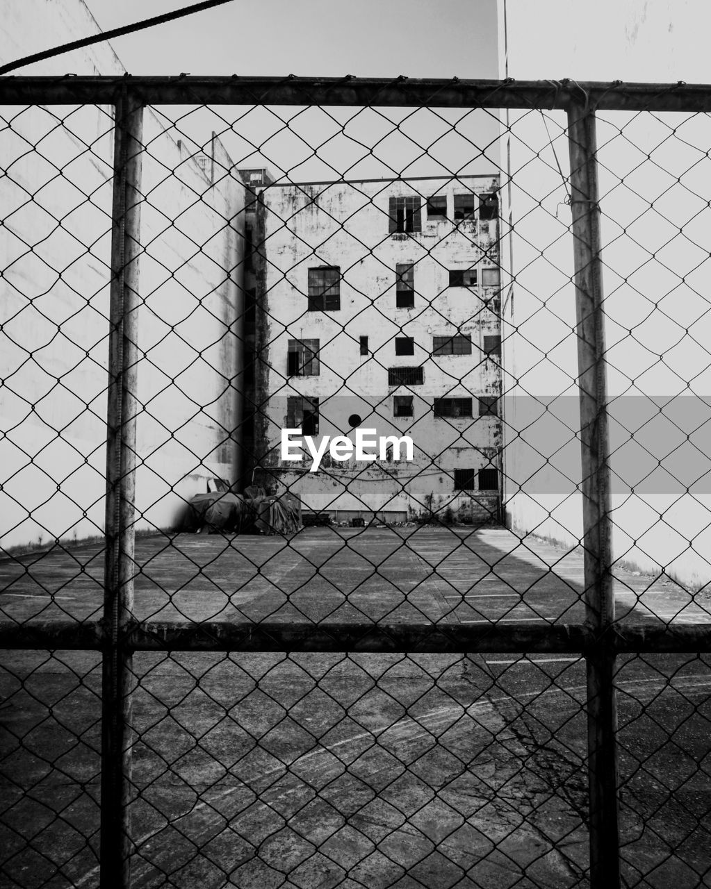 Chainlink fence next to building against clear sky