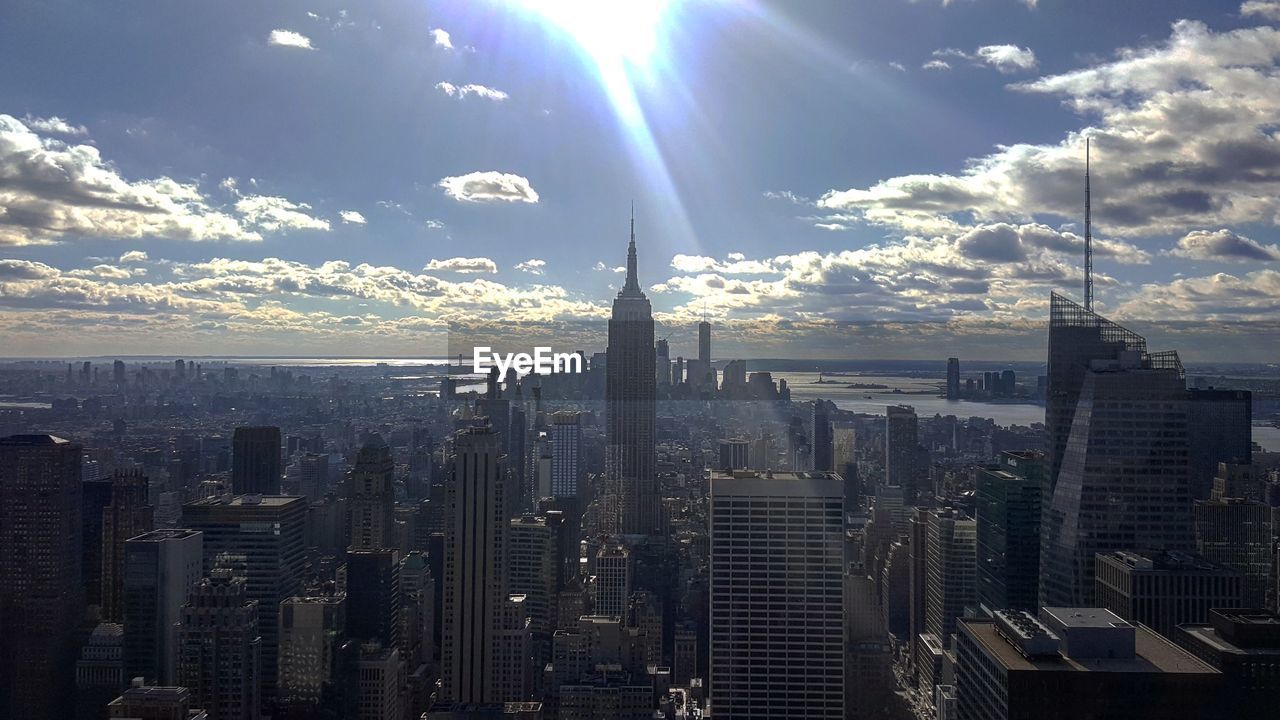 Aerial view of city against cloudy sky