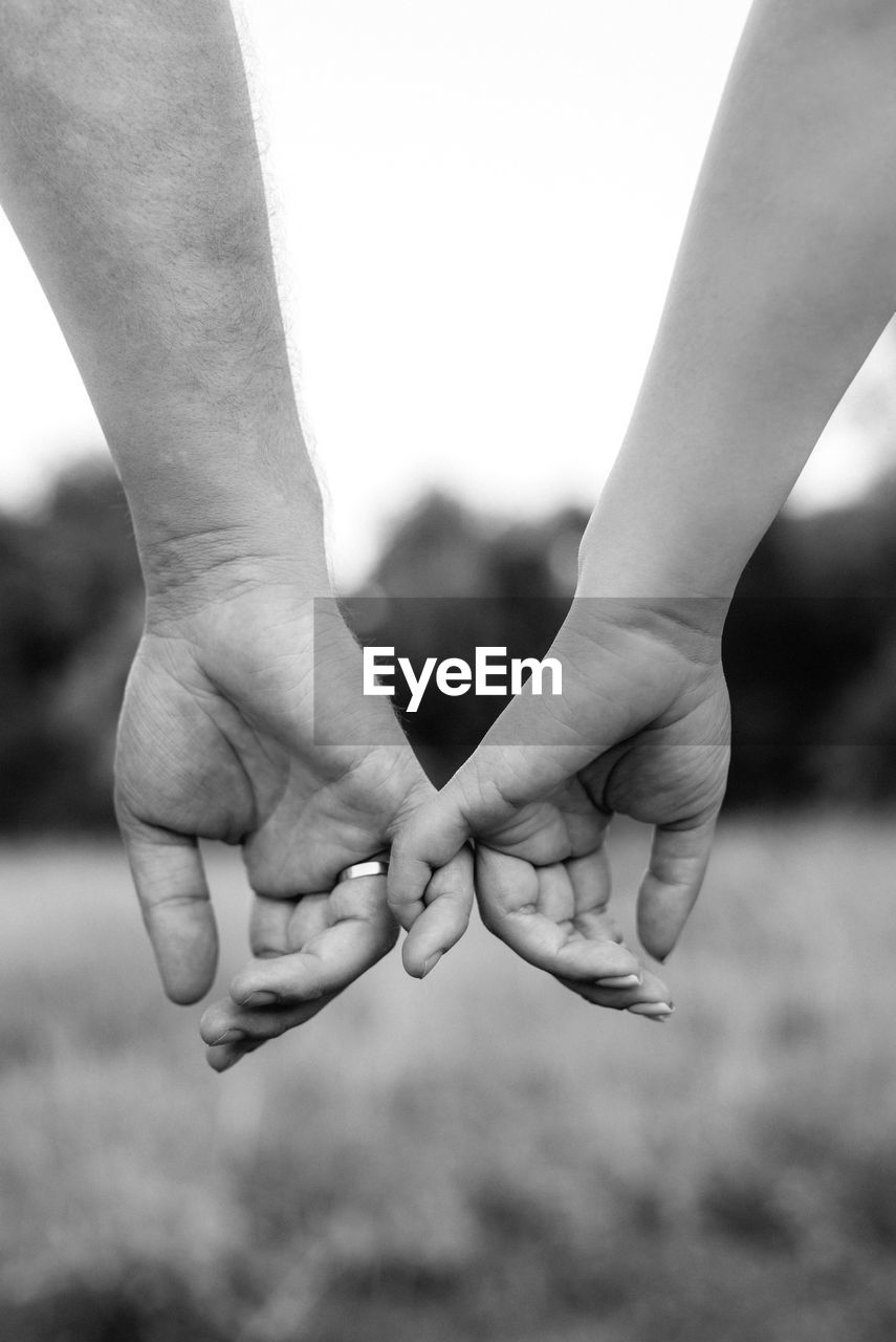 Cropped image of couple holding hands outdoors