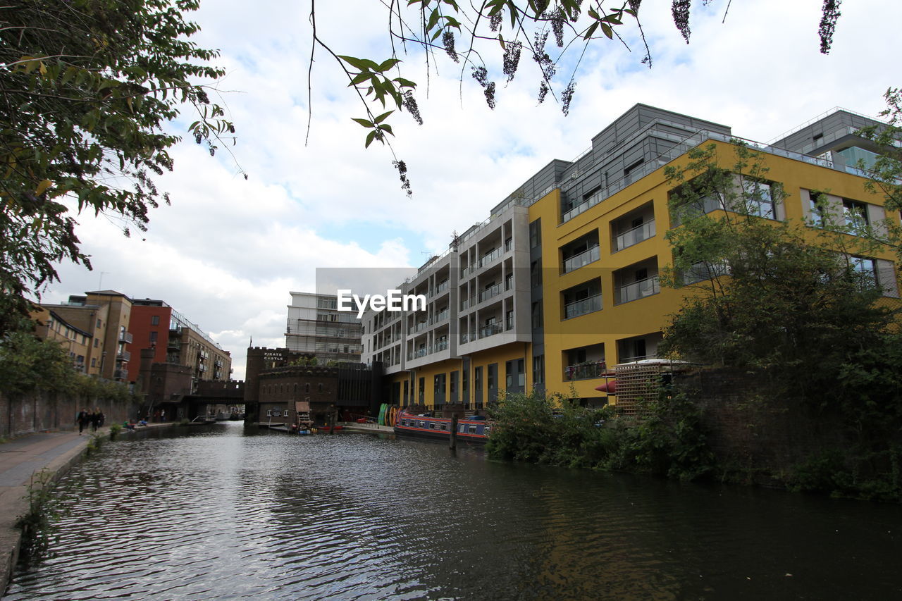 Canal by buildings in city