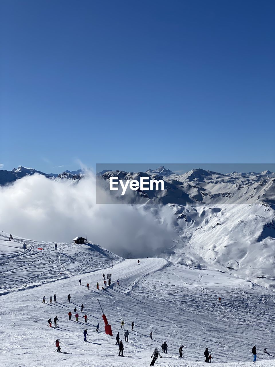 People on snowcapped mountains against sky