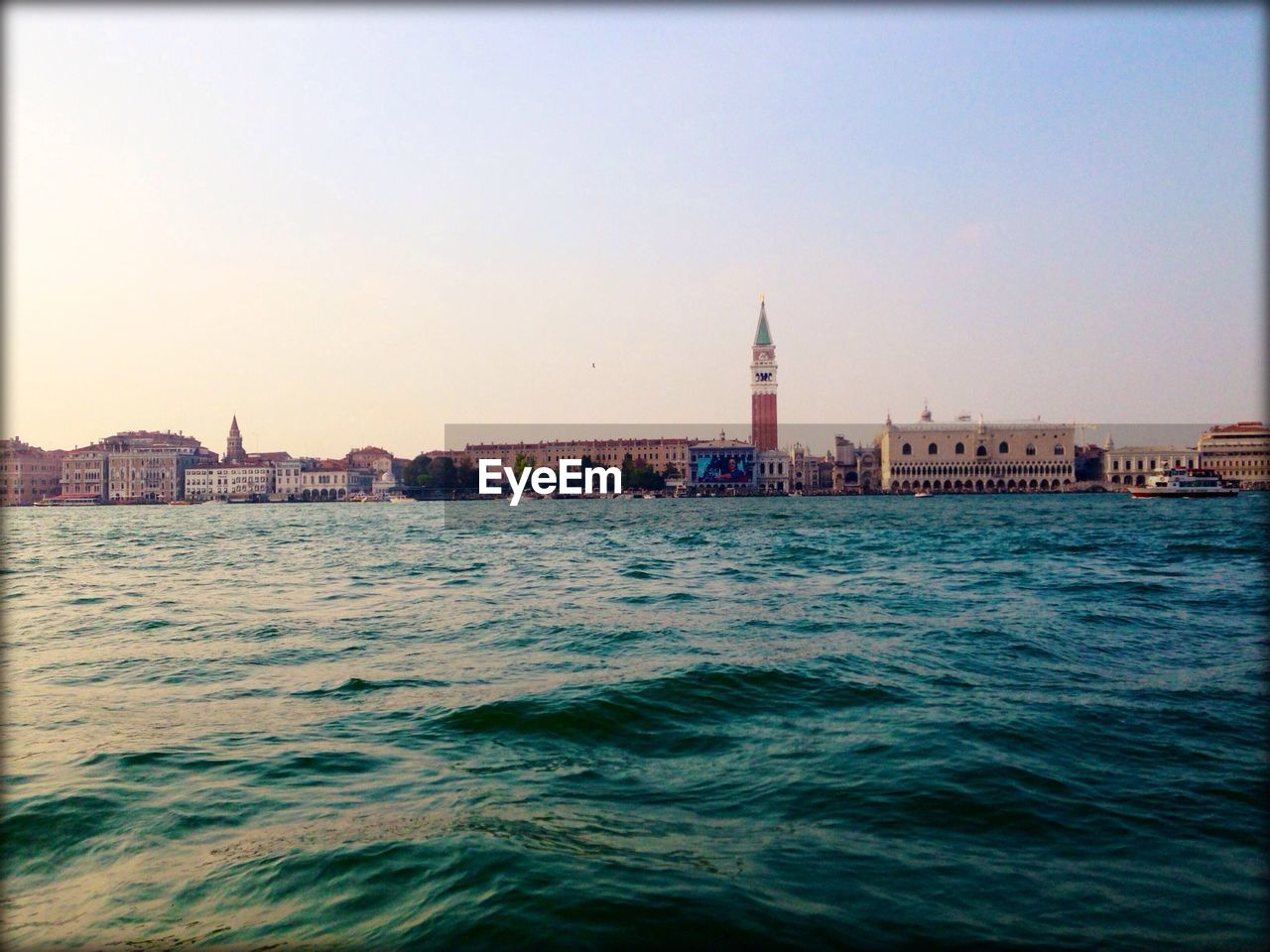 Scenic view of sea by urban skyline against sky