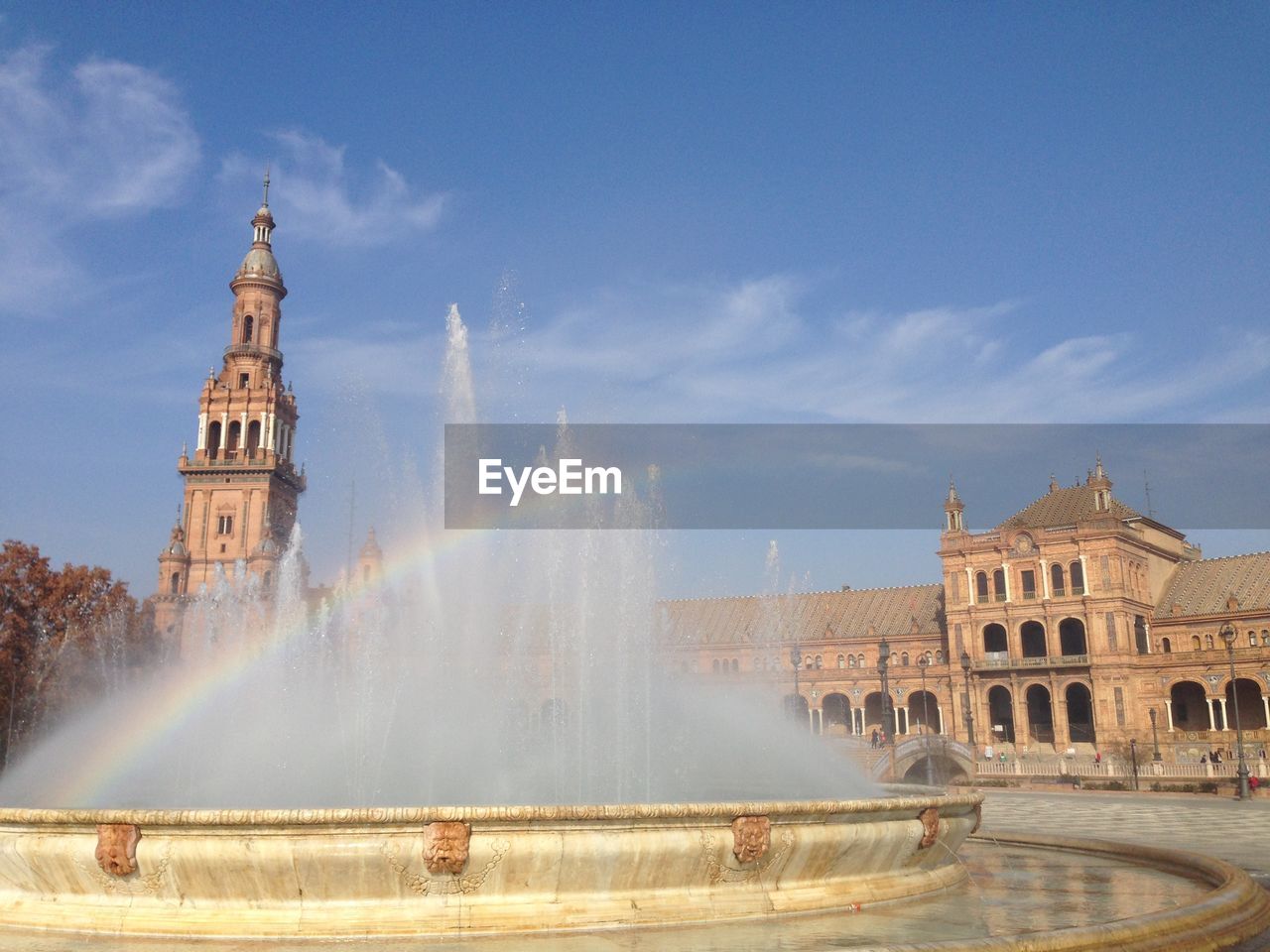 Rainbow over fountain at plaza de espana against sky