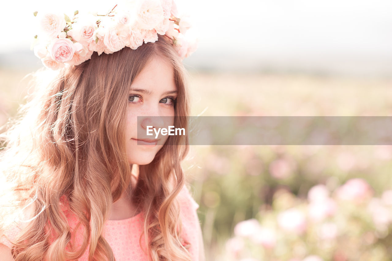 portrait, one person, pink, women, long hair, hairstyle, nature, plant, young adult, flower, adult, flowering plant, summer, beauty in nature, headshot, child, clothing, portrait photography, fashion, contemplation, looking at camera, emotion, sunlight, female, looking, rural scene, landscape, smiling, copy space, brown hair, sky, happiness, springtime, outdoors, land, childhood, relaxation, teenager, environment, field, dress, person, freshness, wreath, daydreaming, tranquility, bride, cute, spring, day, focus on foreground, positive emotion, human hair, redhead, lifestyles, blossom, front view, back lit, skin, fashion accessory, grass, brown eyes, laurel wreath