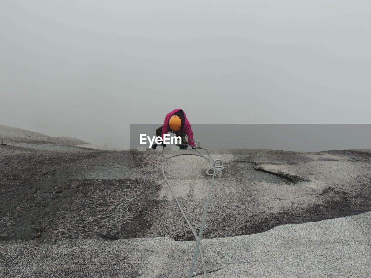 Rear view of man climbing on rock
