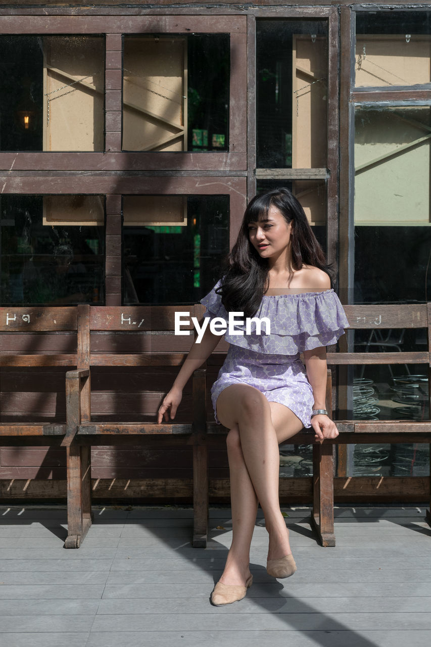 Portrait of happy woman sitting on bench