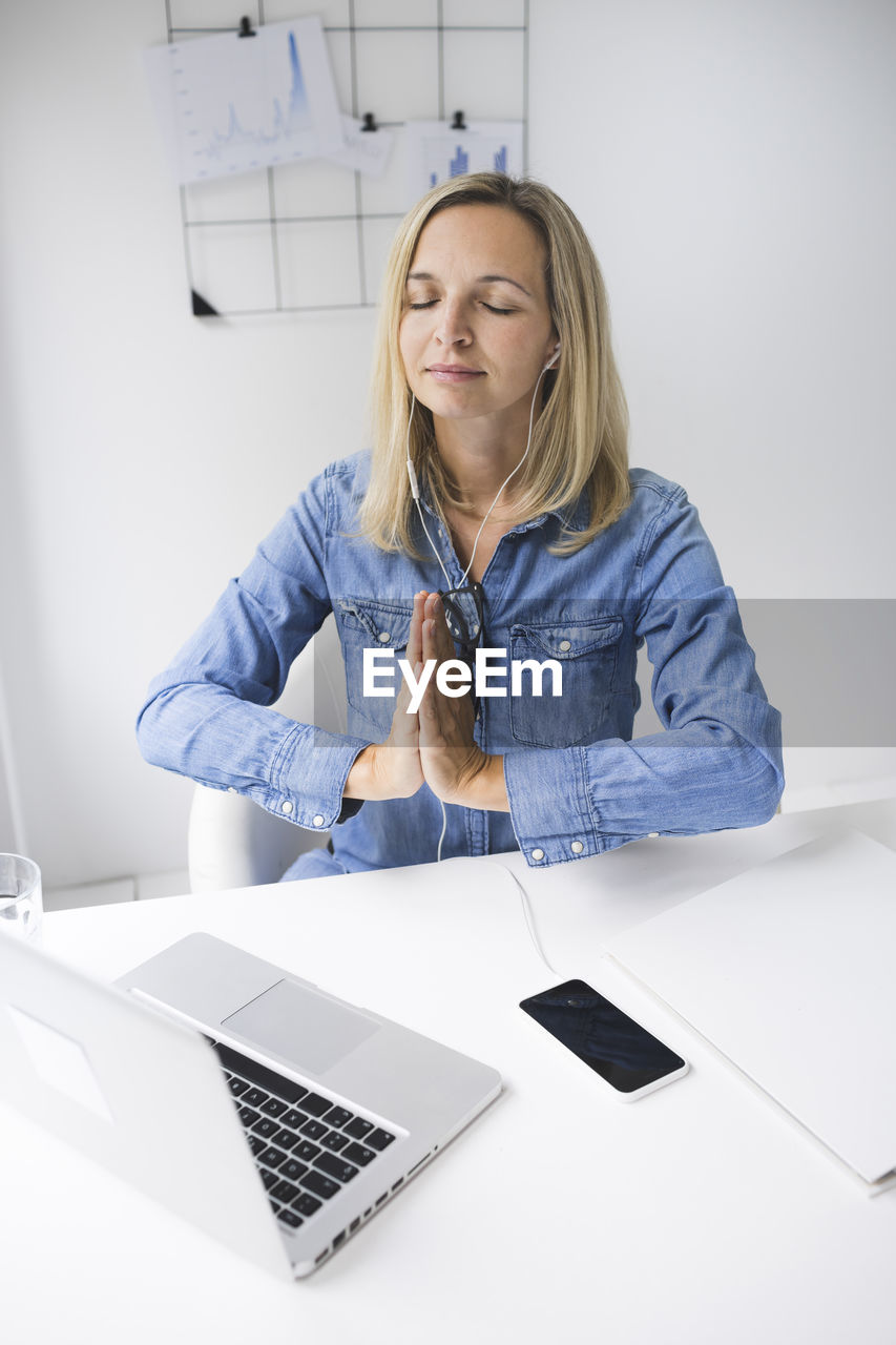 Businesswoman meditating at office