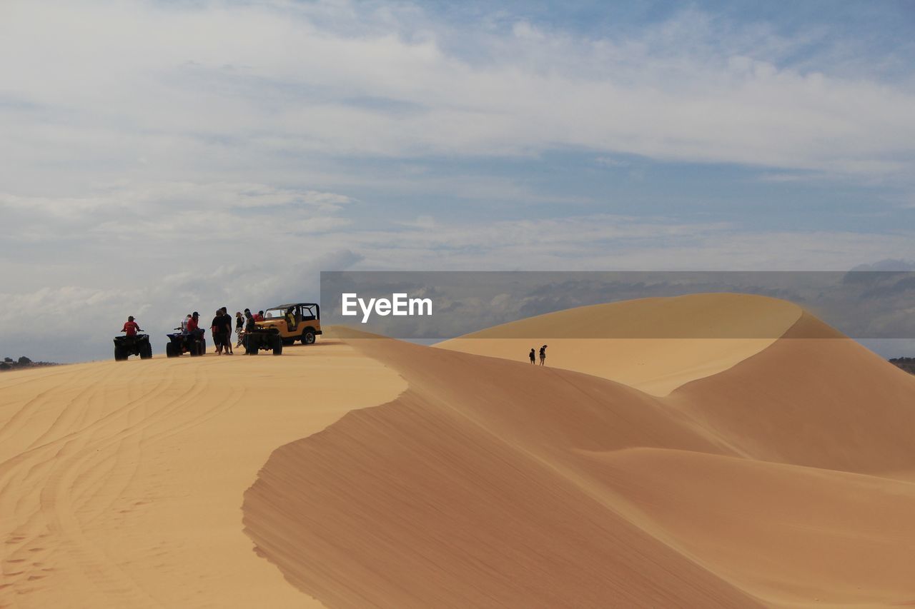 PEOPLE ON SAND DUNE IN DESERT
