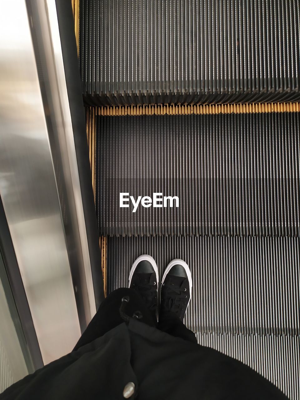 LOW SECTION OF MAN ON ESCALATOR
