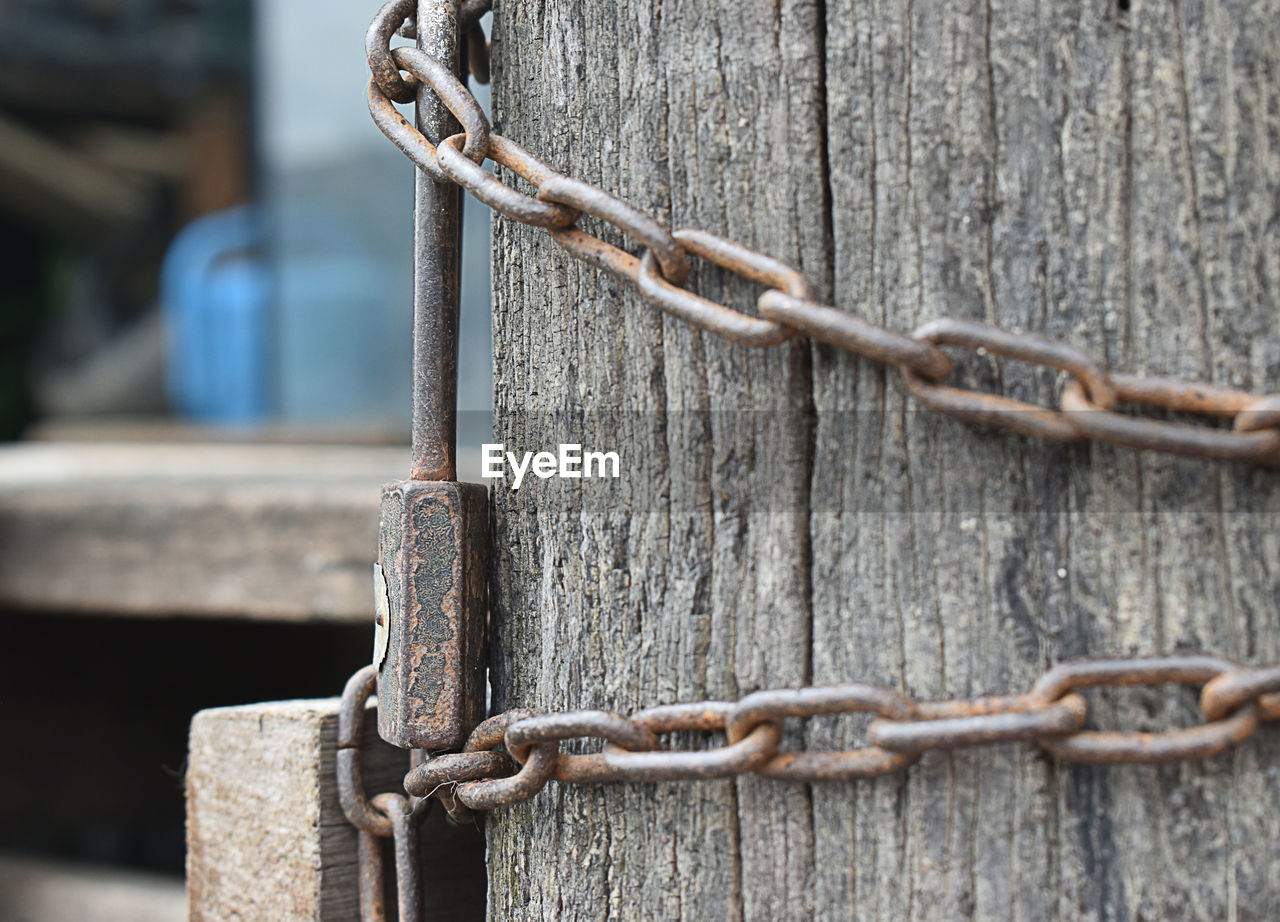 CLOSE-UP OF CHAIN ON WOODEN FENCE