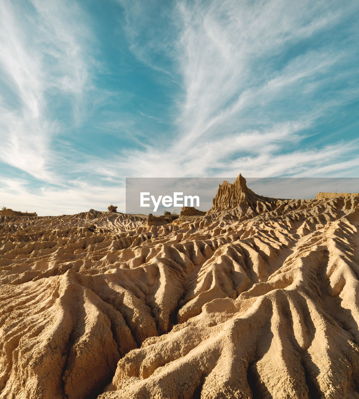 Iconic eroded sand rock formation with dramatic cloud formation in the sky