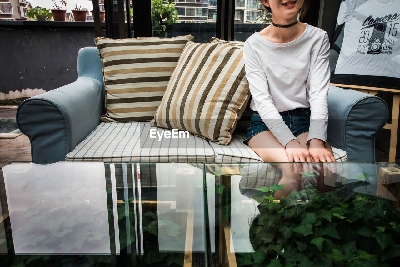 Mid section of a woman sitting on sofa