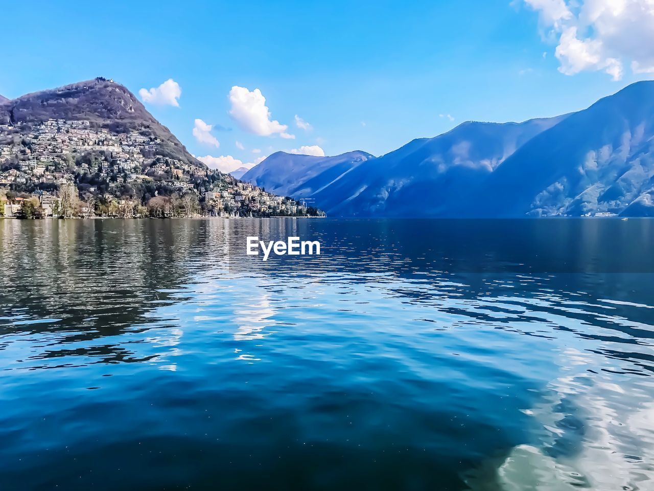 Scenic view of lake by mountains against sky