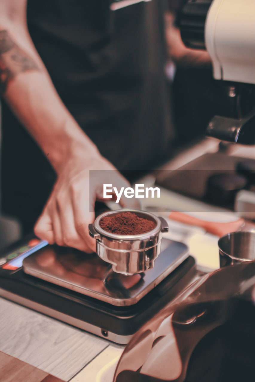 MIDSECTION OF WOMAN HOLDING COFFEE