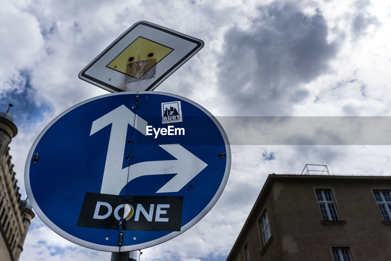 Low angle view of directional road sign against sky