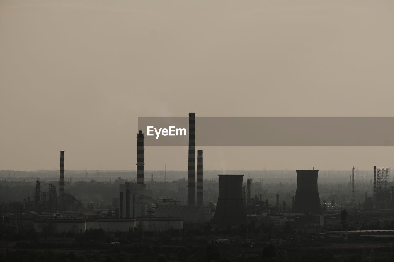 skyline, horizon, building exterior, sky, architecture, built structure, city, pollution, industry, smoke stack, factory, cityscape, morning, no people, dusk, skyscraper, nature, haze, environment, urban area, environmental issues, air pollution, fog, outdoors, landscape, cloud, silhouette, building, power generation, smog