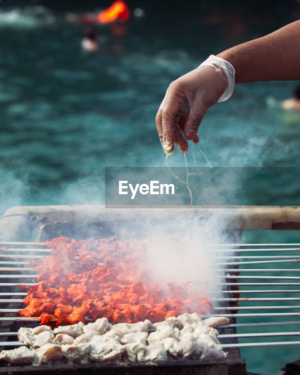 Cropped image of hand holding barbecue grill