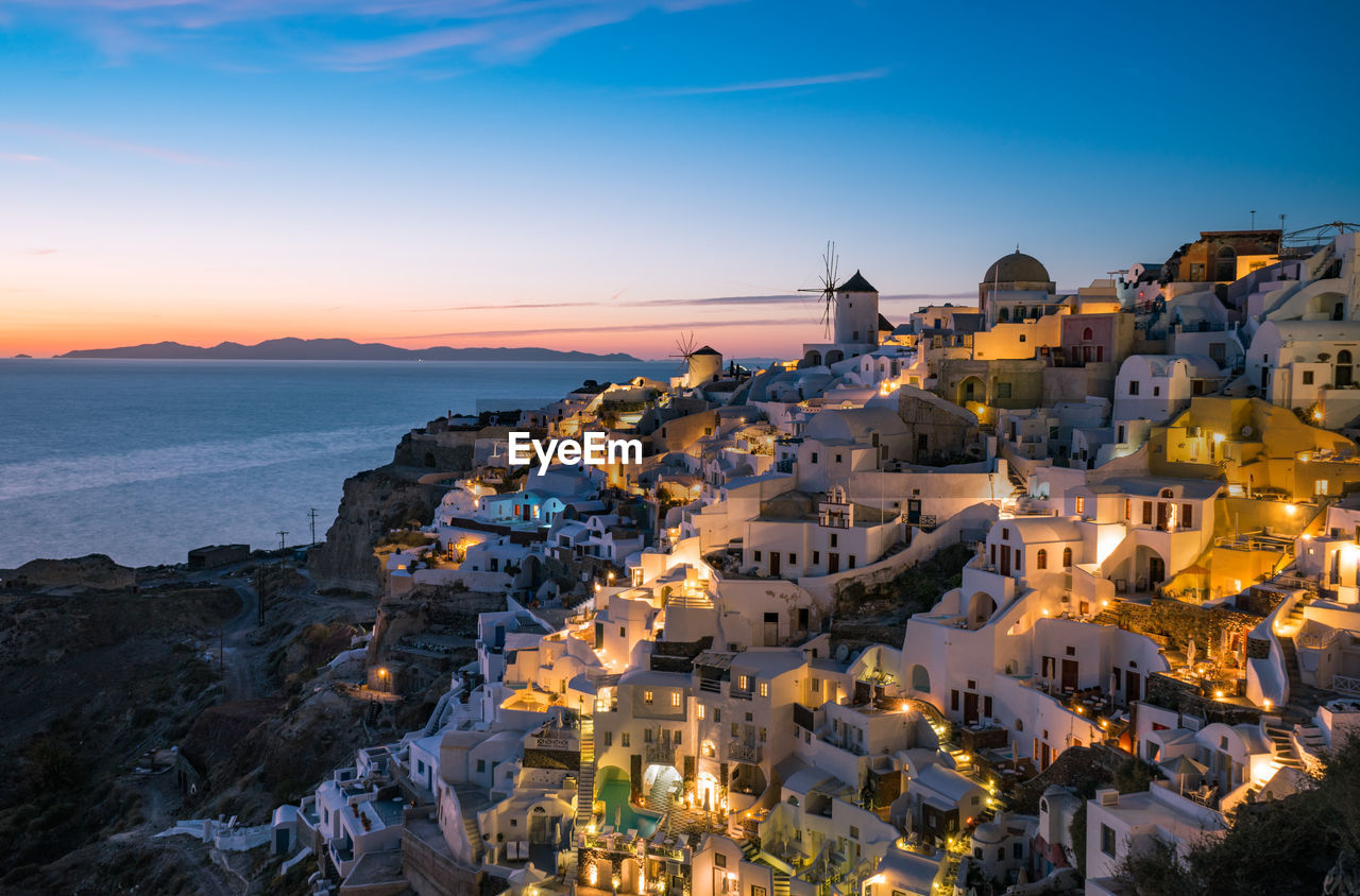 High angle view of townscape by sea against sky